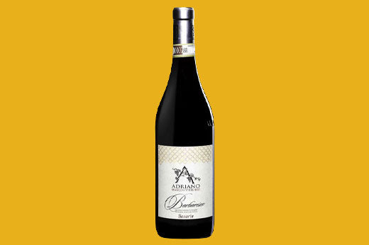 Bottle of 2017 Adriano Barbaresco, cream label with a large A monogram, on a yellow background