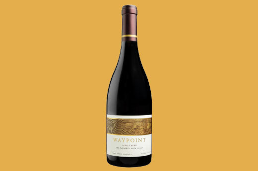 Bottle of 2018 Waypoint Pinot Noir, cream label with a woodgrain pattern, on an amber background