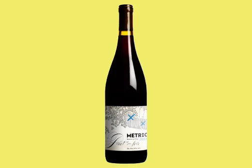 Bottle of 2019 Metrick Pinot Noir, white label with a sketched vineyard scene