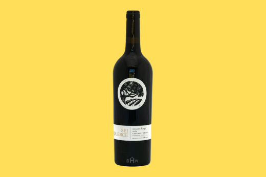 Bottle of 2019 Sei Querce Coyote Ridge Cabernet Franc, black label with a round leaf emblem, yellow background