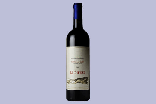 Bottle of 2019 Tenuta San Guido Le Difese, cream label with a hillside drawing, lavender background
