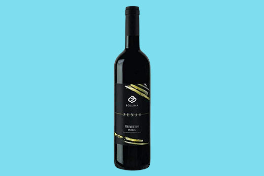 Bottle of 2020 Bollina Zenas Primitivo, black label with gold brushstrokes reading ZENAS, light blue background