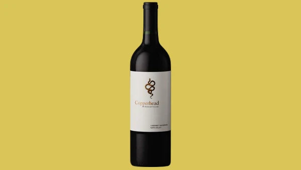 Bottle of Copperhead Cabernet Sauvignon, cream label with a snake illustration, yellow background