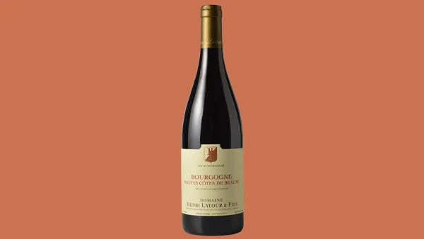 Bottle of Bourgogne Hautes-Cotes de Beaune red wine with a cream label, on a salmon background