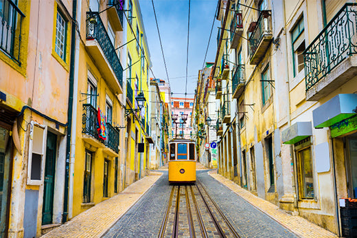 Yellow funicular tram climbing a narrow street lined with colorful buildings in Portugal