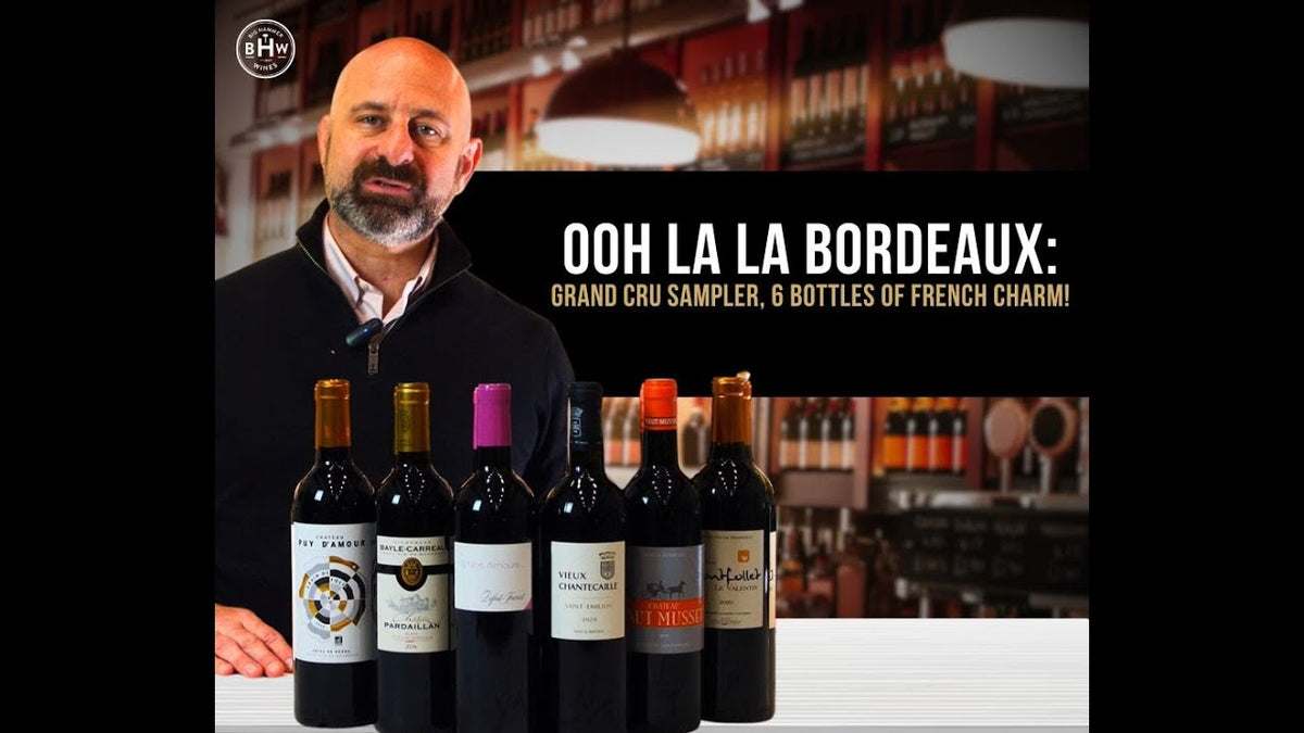 Man behind a bar with six wine bottles, text reading "Ooh la la Bordeaux: Grand Cru Sampler"