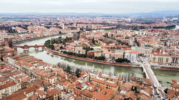 Aerial view over Verona, red-tiled rooftops and bridges along a curving river