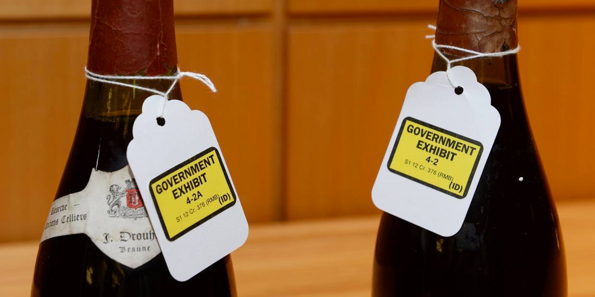 Two wine bottles with Government Exhibit evidence tags tied around their necks