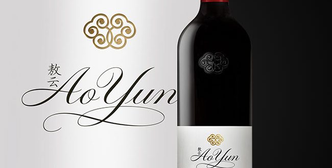 Bottle of Ao Yun red wine beside the Ao Yun name and gold crest logo on a white and black background