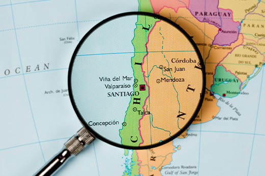 Magnifying glass over a map of Chile, enlarging Santiago, Valparaiso and Vina del Mar