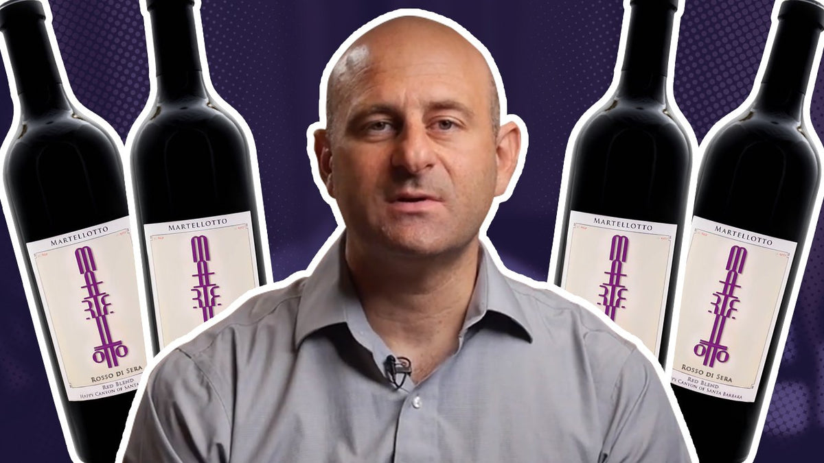 Man in a grey shirt flanked by four bottles of Martellotto Rosso di Sera