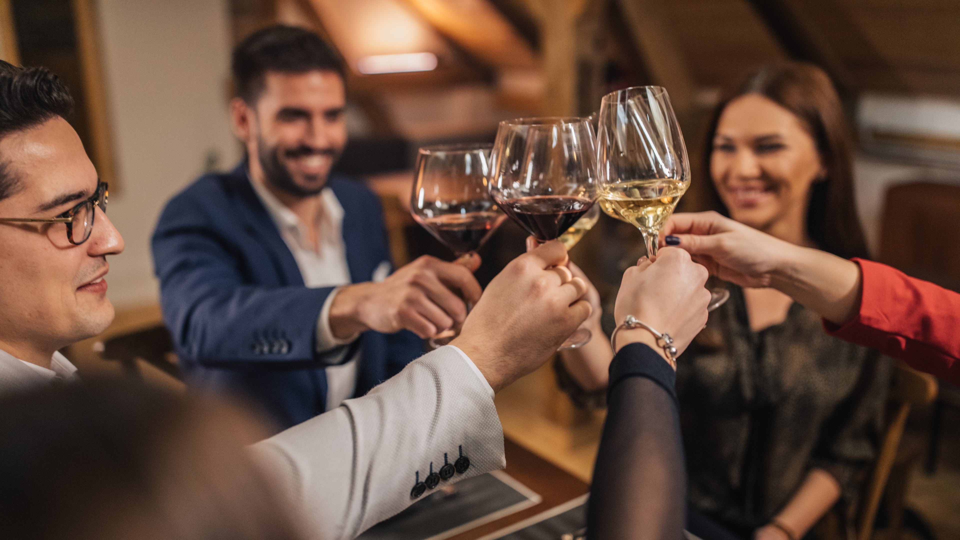 Friends enjoying wine together during a wine tasting conversation about grape varieties and wine regions.