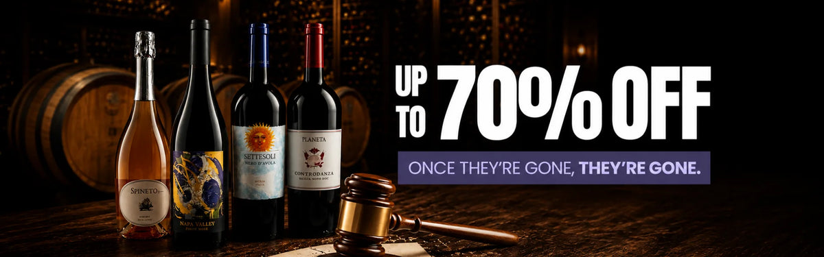 Wine bottles on a wooden table with a gavel, indicating a sale event.