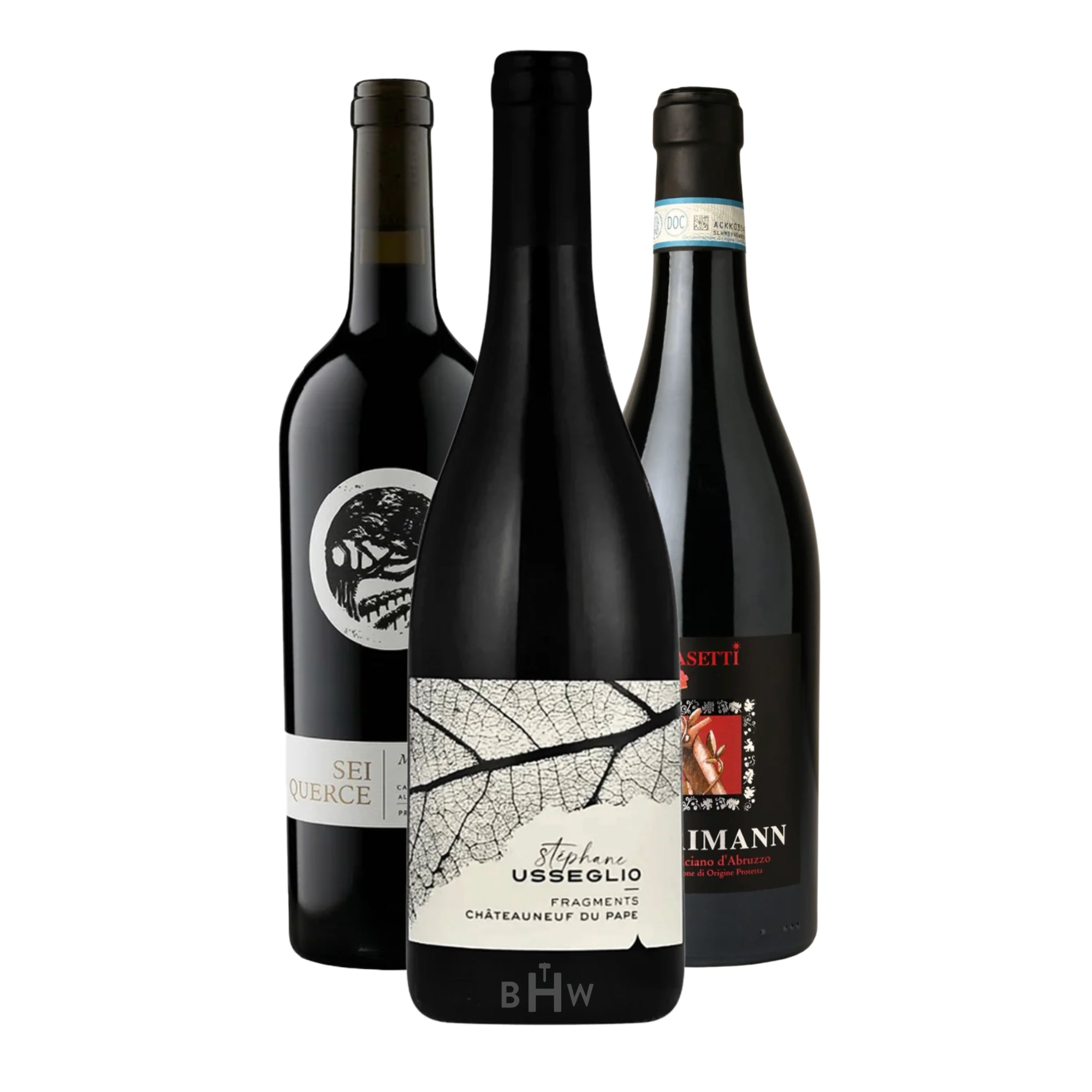 A trio of premium red wines: 2018 Sei Querce Miller’s Orchard Cabernet Sauvignon (94 pts Decanter), 2022 Stephane Usseglio Fragments Châteauneuf-du-Pape (95 pts James Suckling), and 2018 Pasetti Harimann Montepulciano d’Abruzzo. The bottles are arranged against a white background, highlighting the distinct label designs like the skeletal leaf on the Usseglio. Curated by Big Hammer Wines.