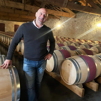 Greg Martellotto, Founder of Big Hammer Wines, touring Château Pontet-Canet’s barrel room, surrounded by oak barrels used for aging their prestigious Bordeaux wines