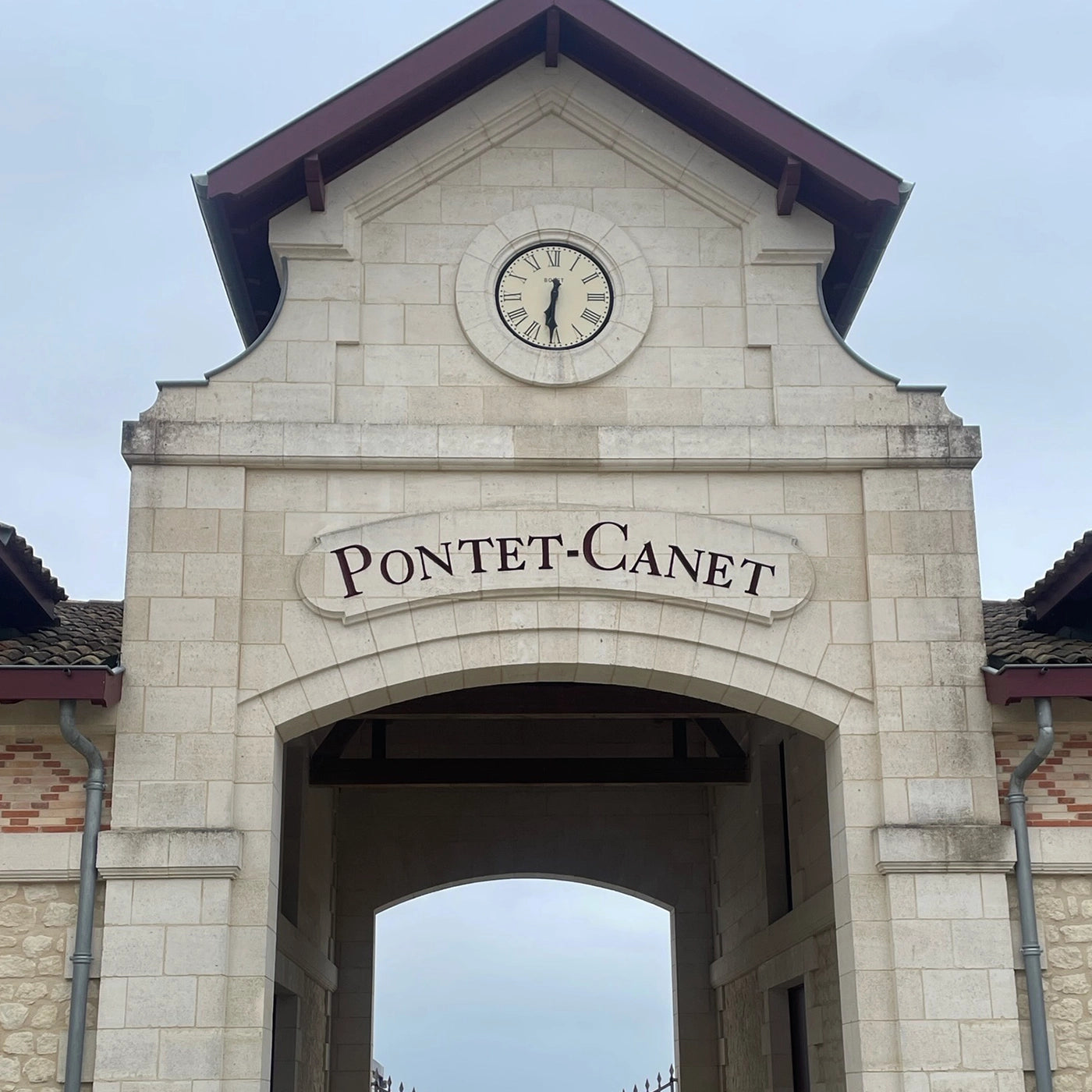 Château Pontet-Canet entrance with clock tower, showcasing the winery’s grand architecture and its iconic sign in the heart of Bordeaux’s Pauillac appellation
