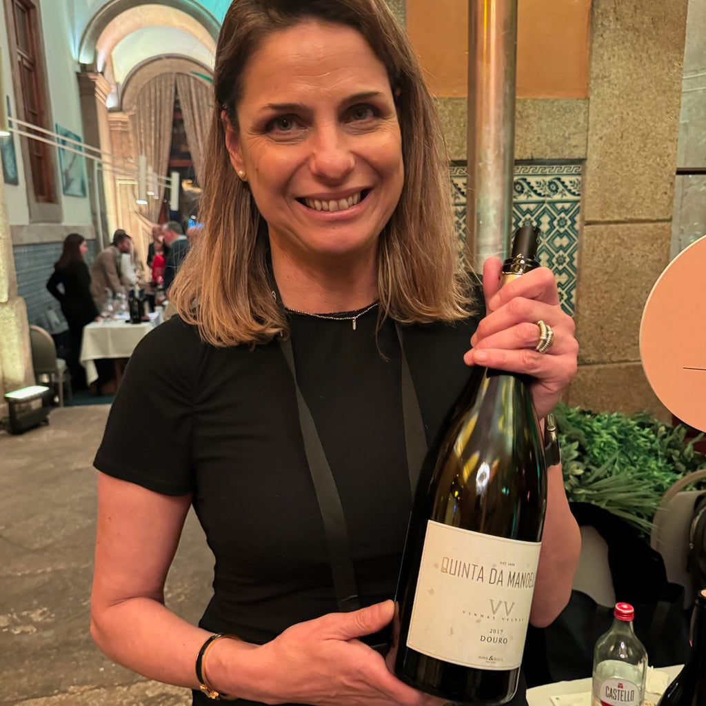 Sandra Tavares da Silva, Co-Owner and Founder of Wine & Soul, holding a bottle of Quinta da Manoella Vinhas Velhas Douro Red Blend at a wine event